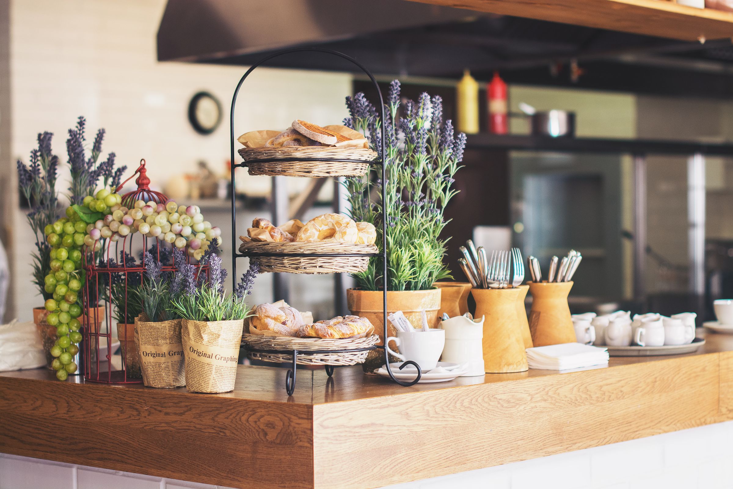 A café counter with cakes and pastries on stands.
