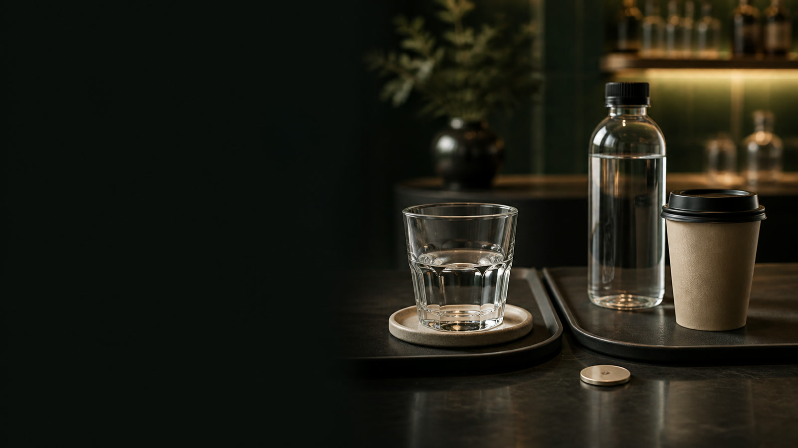 Editorial restaurant counter with a drinks bottle and takeaway cup.