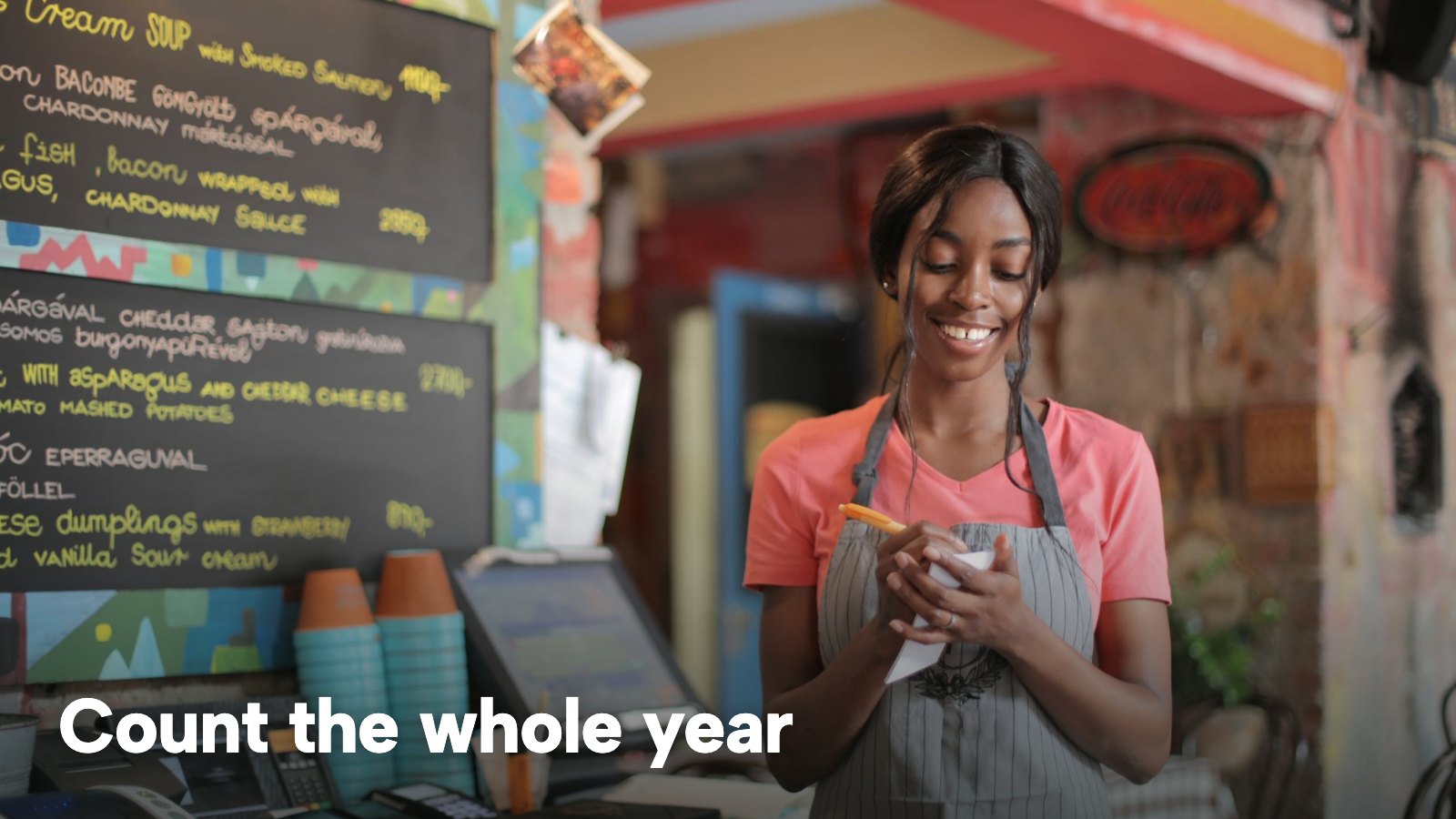 A smiling waitress writing down an order in a restaurant. The image carries the words "Count the whole year".