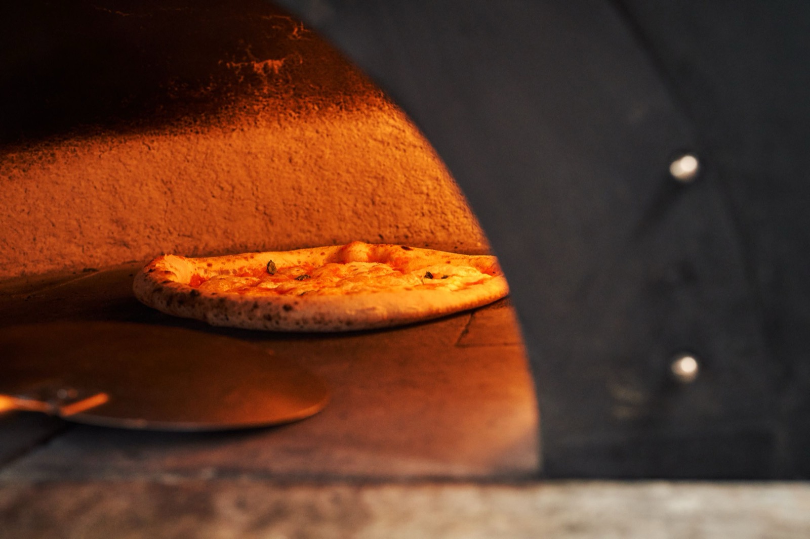 A Neapolitan pizza baking in a wood-fired oven.