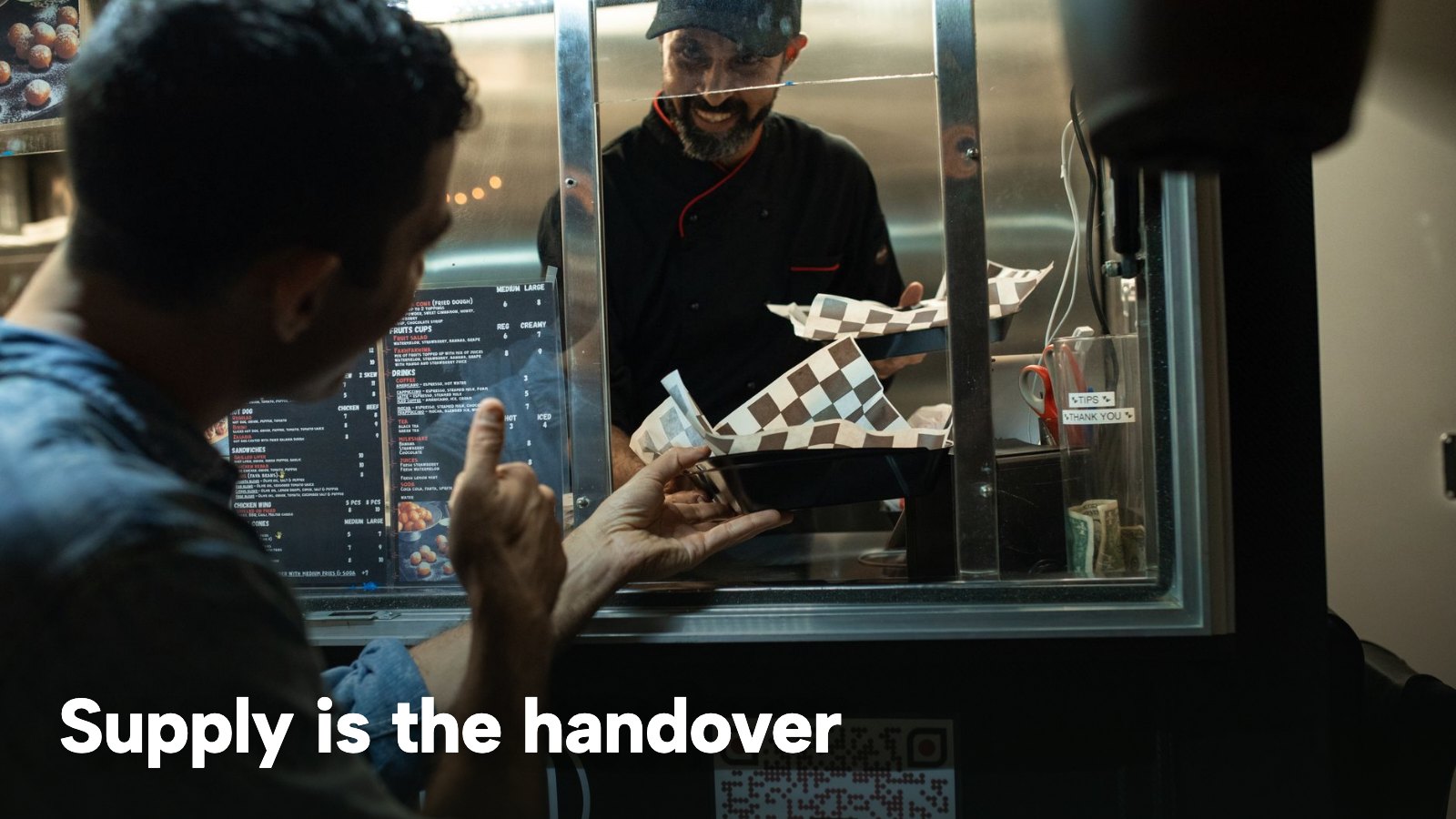 A customer handing over payment at a takeaway window at night. The image carries the words "Supply is the handover".
