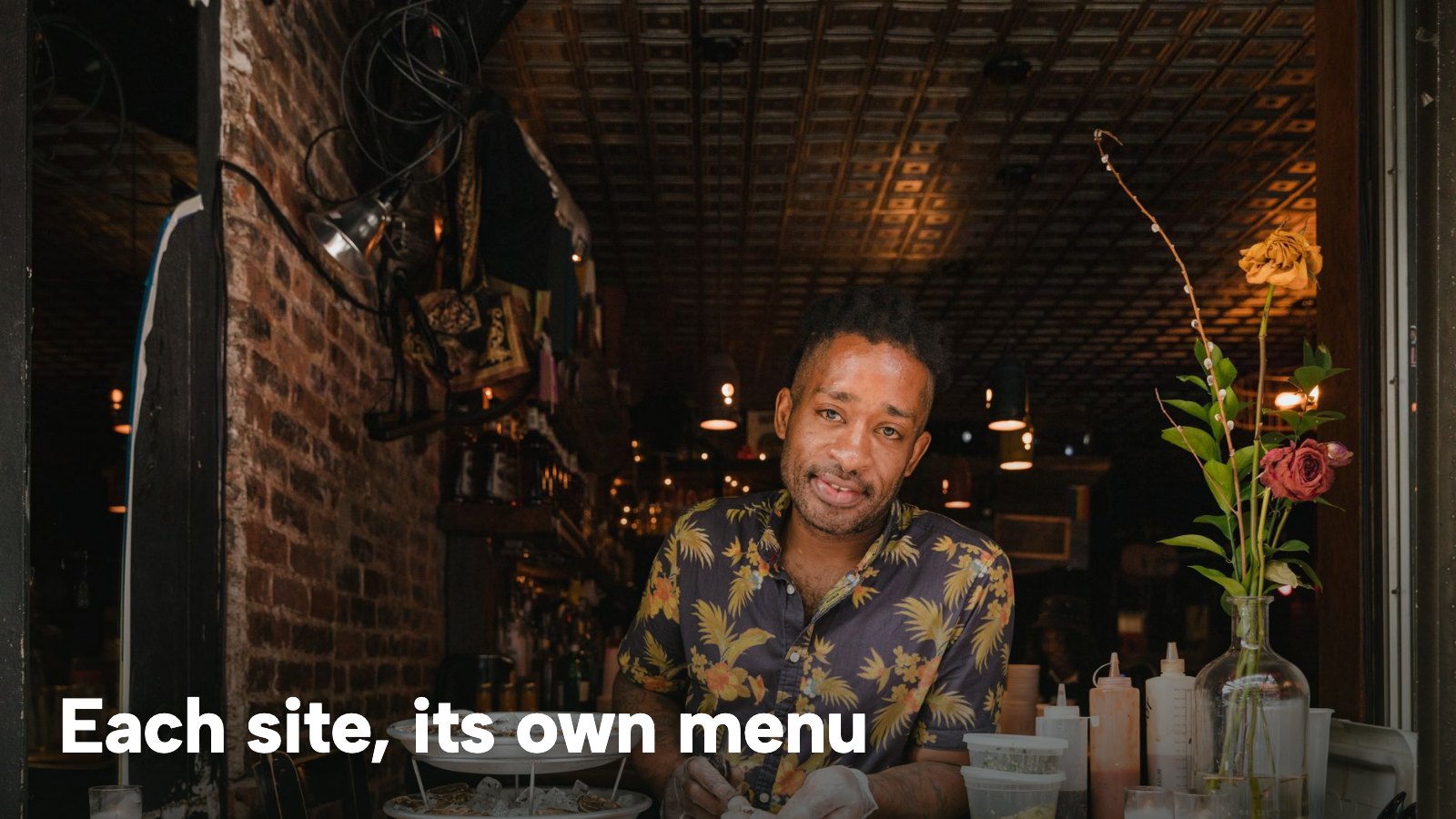 An owner in a patterned shirt prepares oysters at the counter of a dimly lit restaurant. The image carries the words "Each site, its own menu".