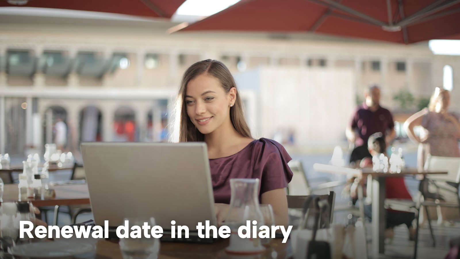 A woman works on a laptop at an outdoor café table. The image carries the words "Renewal date in the diary".