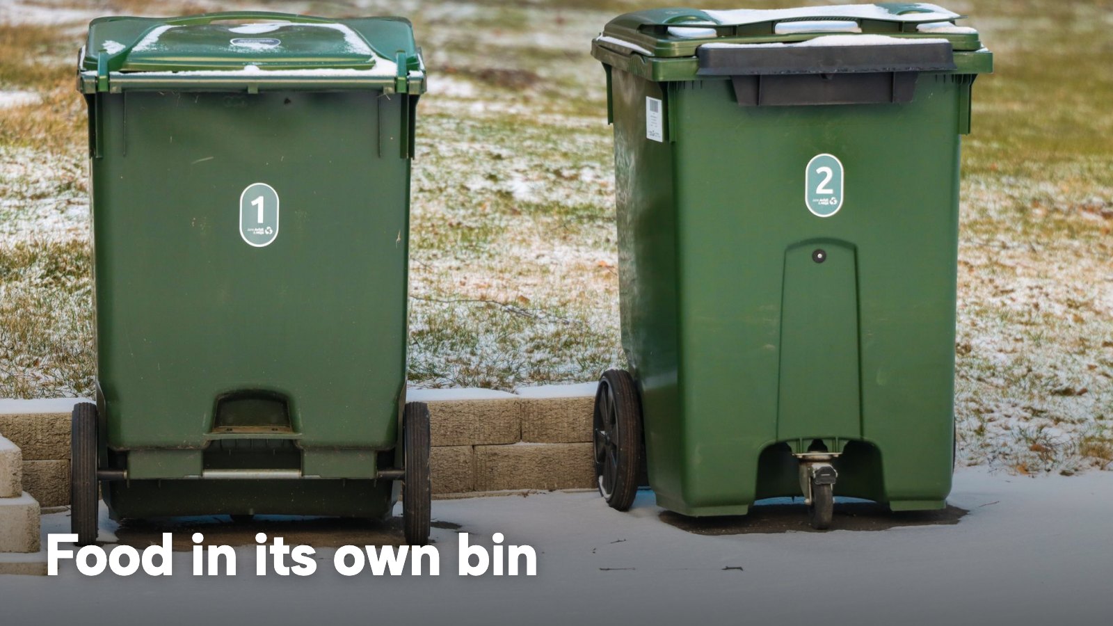 Two green wheelie bins standing side by side outside. The image carries the words "Food in its own bin".