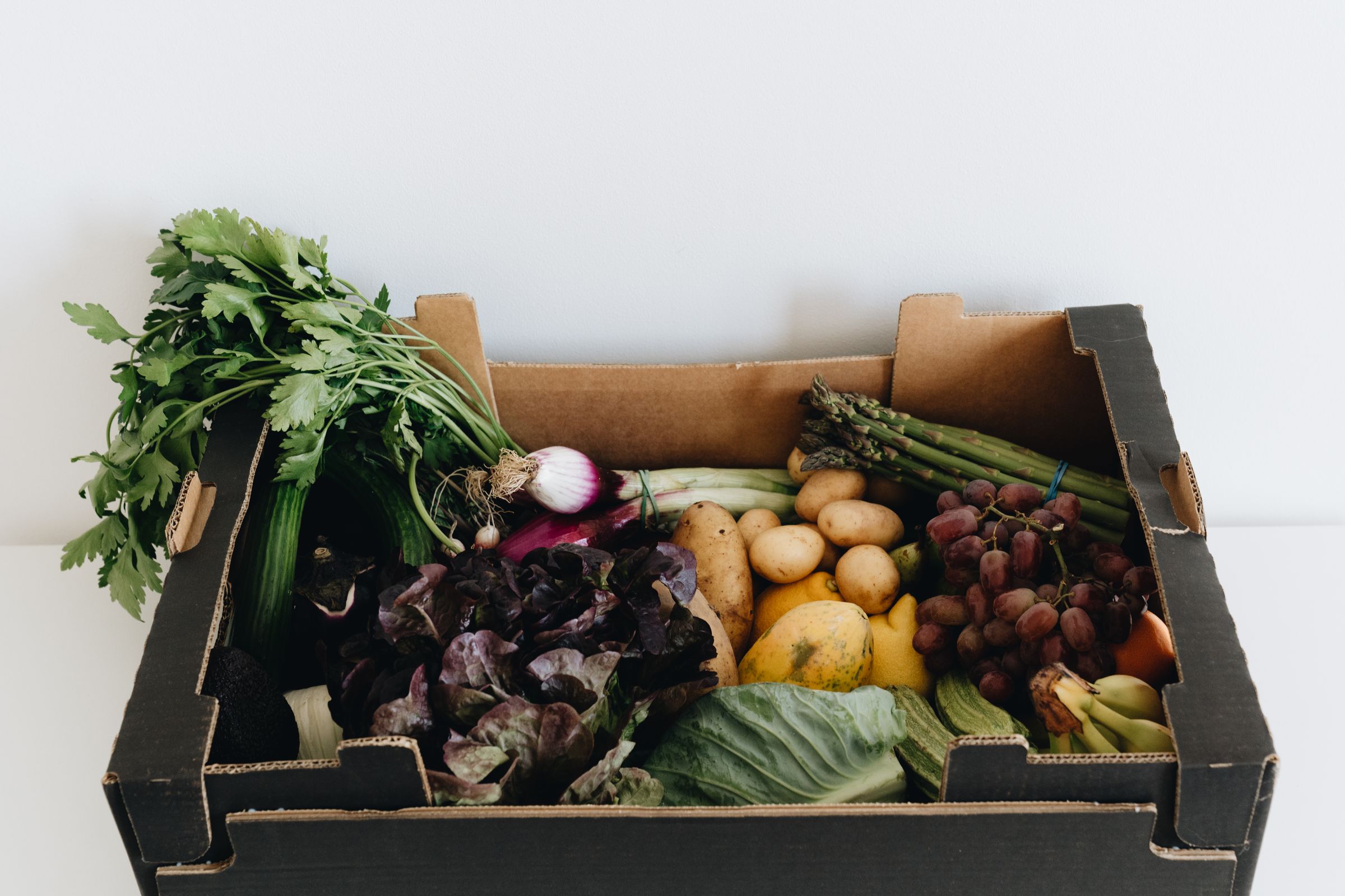 A crate of fresh vegetables delivered to a kitchen.
