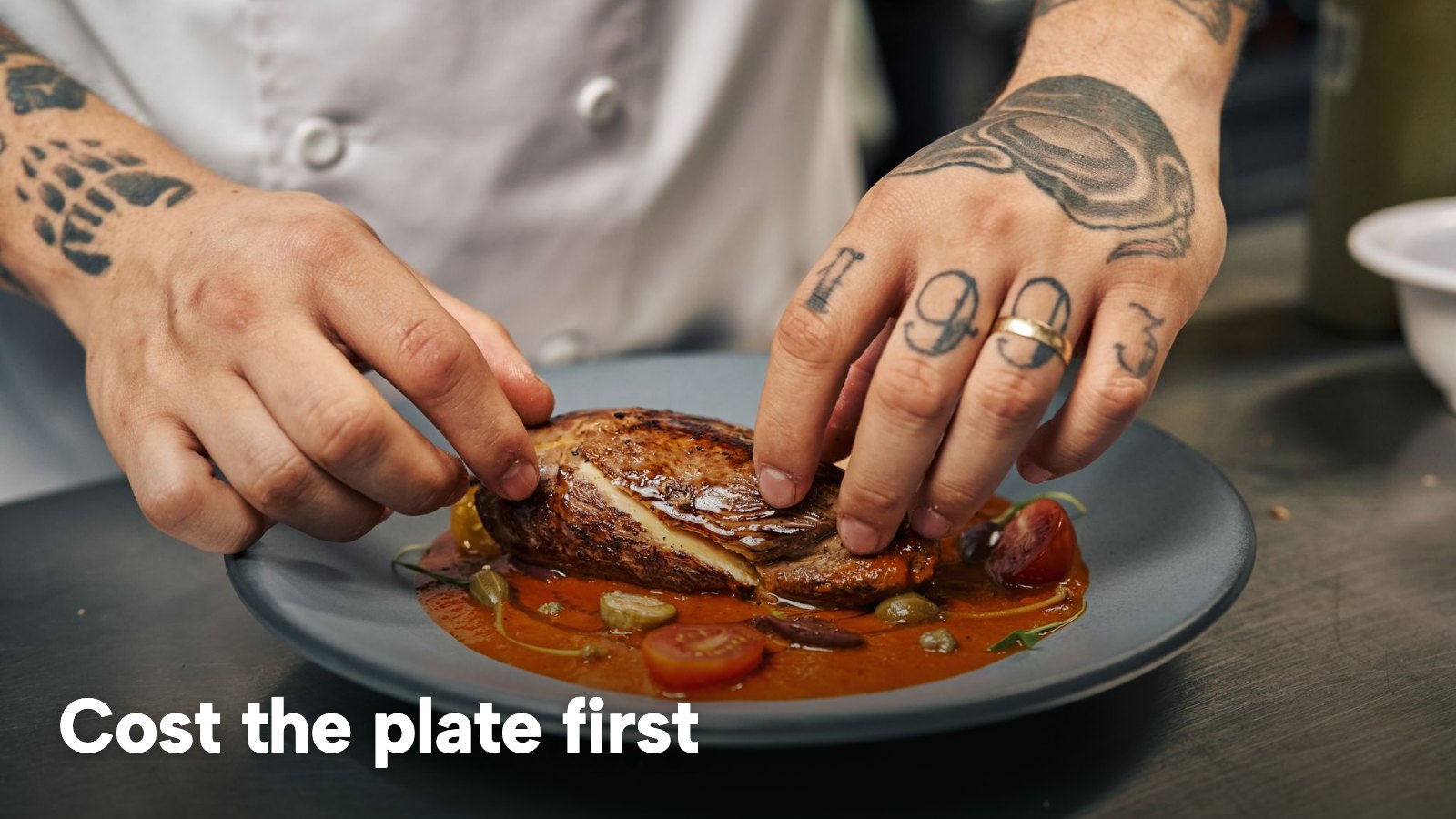 A chef's hands finishing a plated main course on the pass. The image carries the words "Cost the plate first".