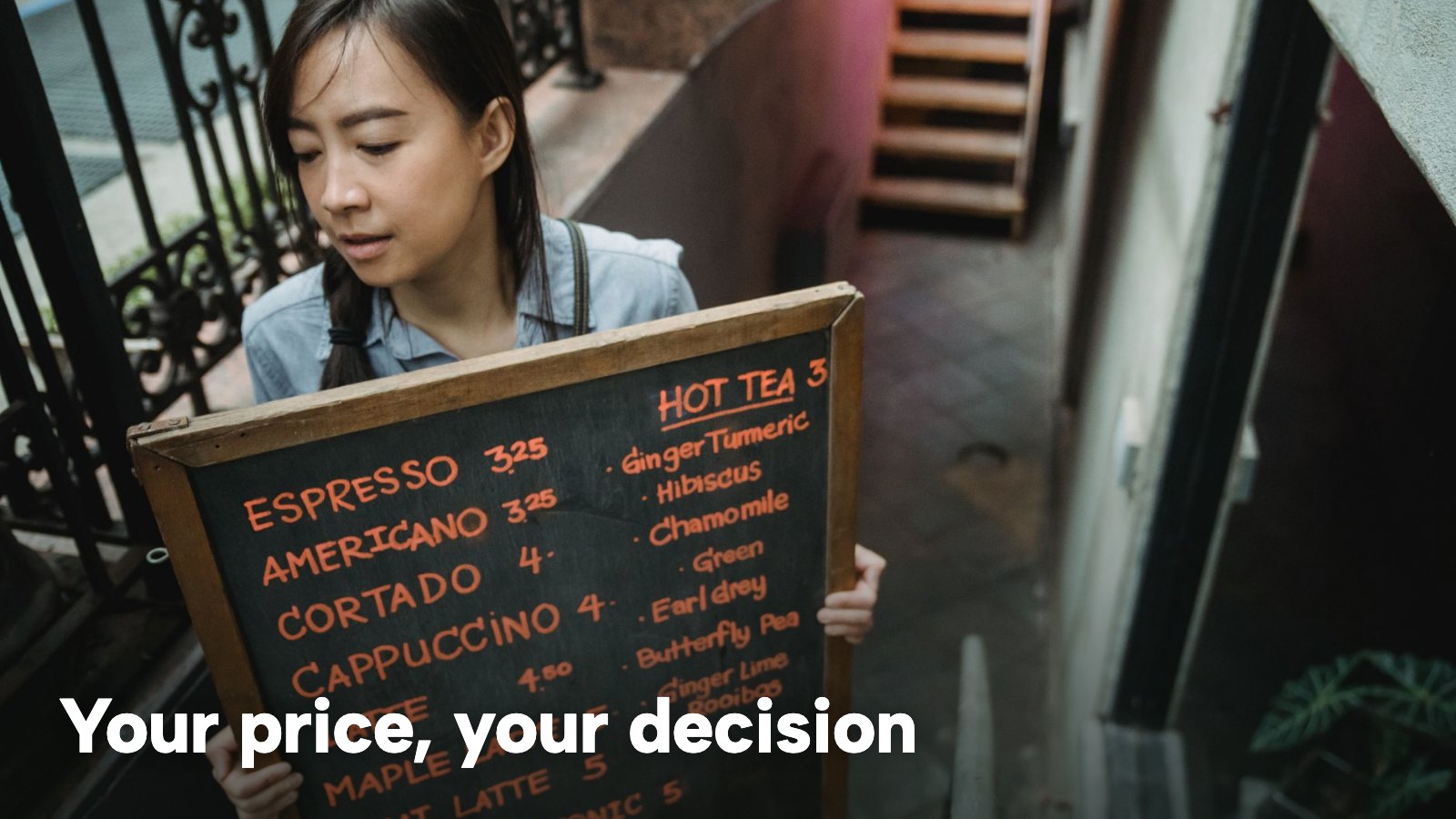 A café worker holding a chalkboard menu with handwritten prices. The image carries the words "Your price, your decision".