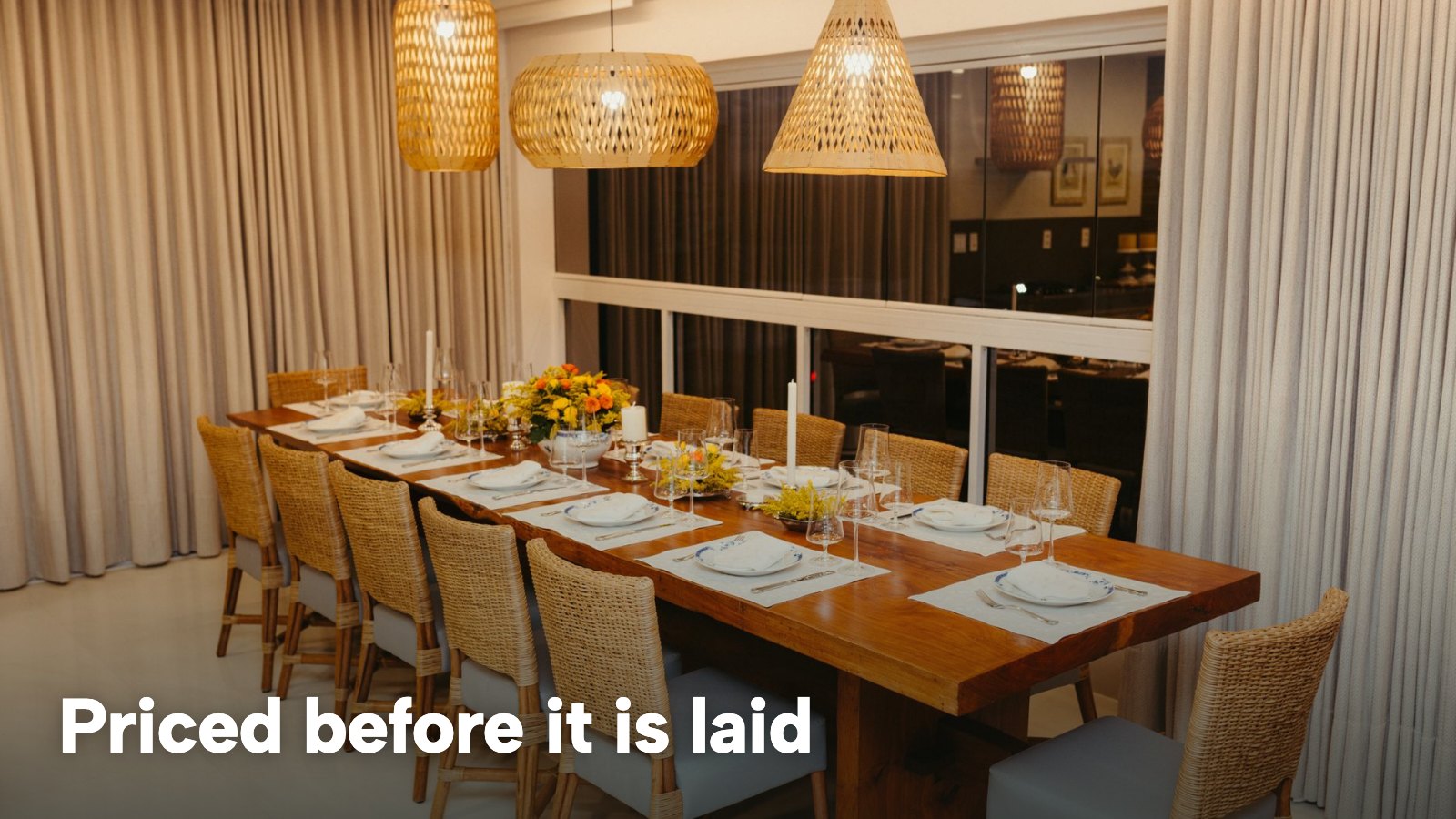 A private dining room with a long wooden table laid for a dinner party. The image carries the words "Priced before it is laid".