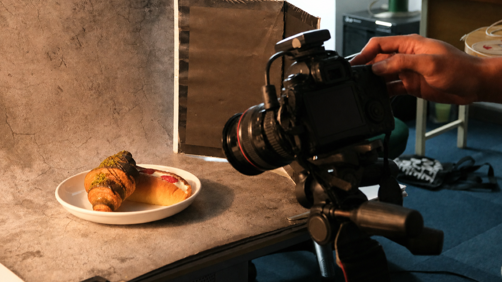 A camera photographing plated food inside a restaurant.